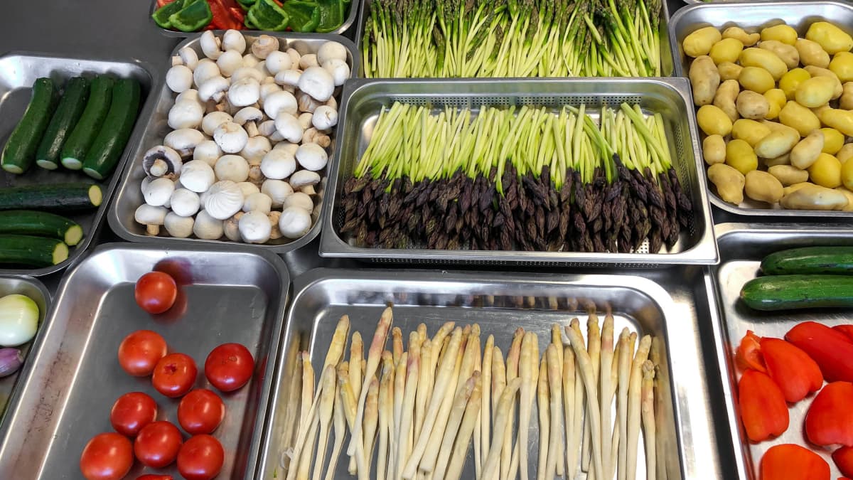 Mise en place de légumes dans des bacs inox