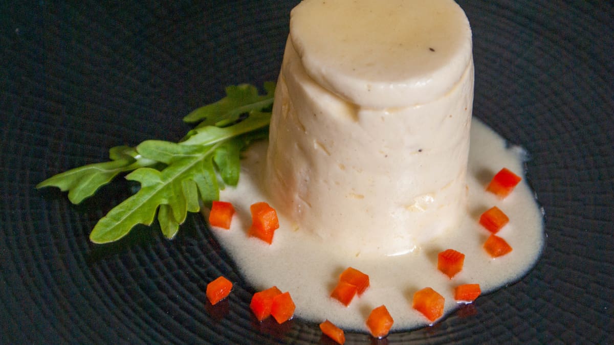 Dariole de cuisses de grenouilles sur assiette noire