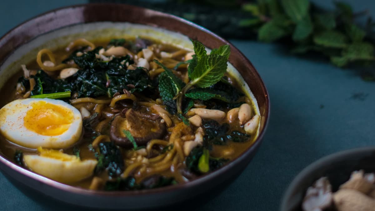 Soupe de noodles au chou kale, cacahuètes, lait de coco et curry ...