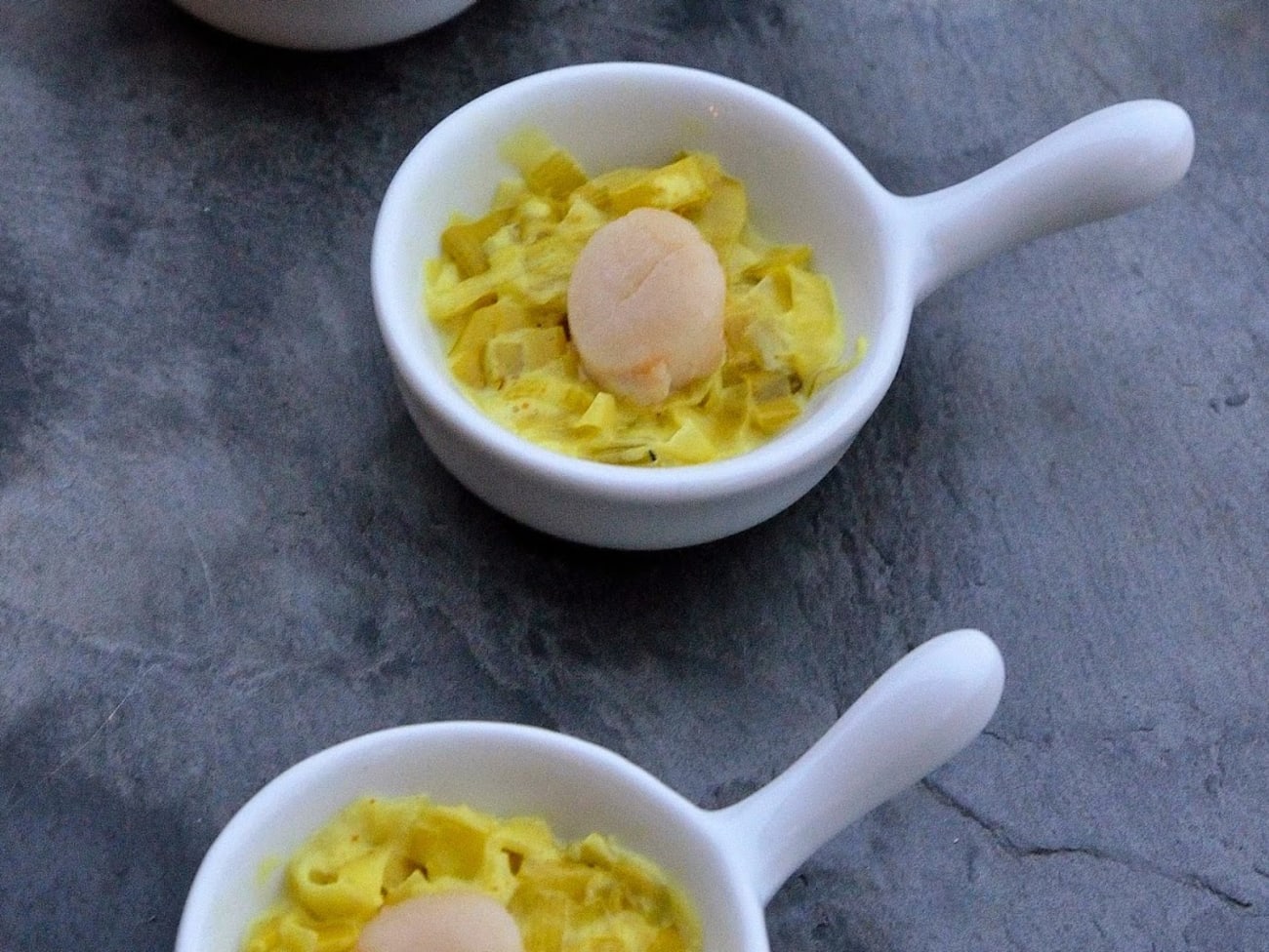 Fondue de poireaux au curcuma et noix de pétoncle, en minicassolette