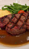 Filet de boeuf grillé, sauce au poivre noir, gratin dauphinois et haricots verts
