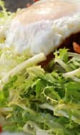 Salade frisée, oeuf frit, bacon et tomates