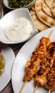 Brochettes de poulet chich taouk, sauce à l'ail, taboulé et houmous