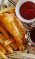 Poisson frit, frites et sauce dans un journal