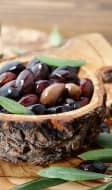 Olives de Kalamata et feuilles d'olivier dans un bol en bois