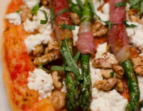 Pizza aux asperges vertes enroulées dans du jambon de Parme