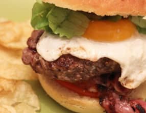 Burger au chèvre, steak haché, bacon et œuf sur le plat