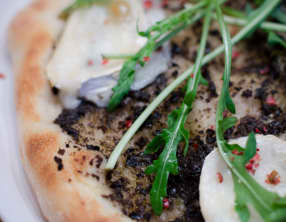 Pizza à la tapenade noire, au chèvre et à la roquette