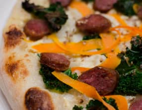 Pizza au chou kale, aux tagliatelles de carottes et aux saucisses fumées