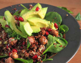 Salade de quinoa rouge, avocat, grenade, noisettes et pousses d'épinards