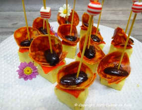 Tapas de polenta à l'origan, chorizo de Bellotta, piquillos et olives de Kalamata en amuse-bouche