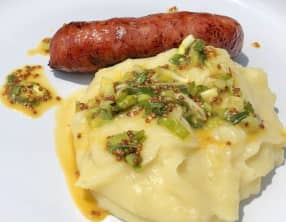 Purée, saucisse à la sauce moutarde et cébettes