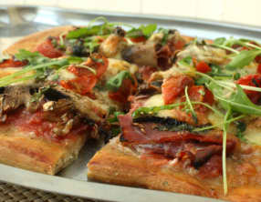 Pizza jambon cru, champignons, tomates cerises et mozzarella