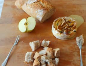 Camembert rôti au four aux pommes, miel et mélange de raisins et noix.