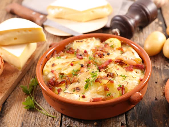 Tartiflette savoyarde dans un plat rond sur table en bois