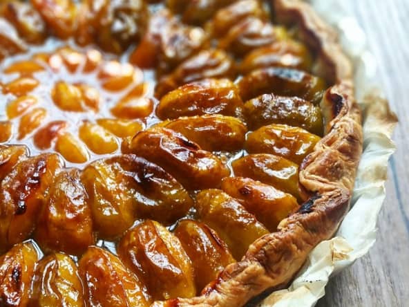 Tarte aux prunes reines-claudes, mirabelles, poudre d'amandes et sirop au curry