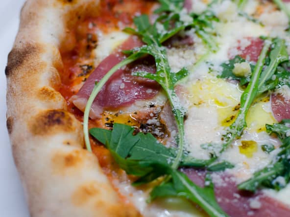Pizza au magret de canard fumé, à la roquette et au parmesan