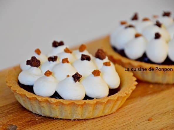 Tartelette de ganache au chocolat garnie de chantilly à la pêche de vigne sur un lit de poire Williams