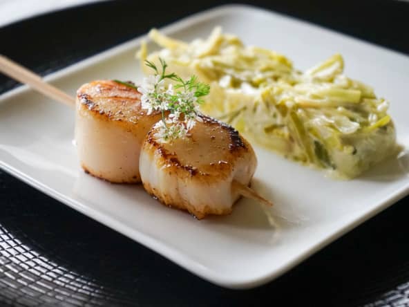 Assiette de brochette de noix de saint-jacques et fondue de poireaux