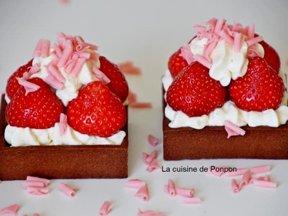 Tartelette chocolat noir garnie de ganache au chocolat blanc, fraise et ail noir