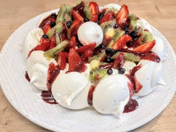 Pavlova aux fraises, kiwi et coulis de fruits rouges
