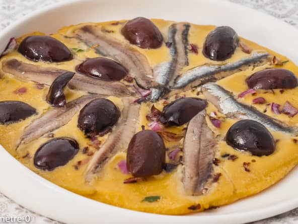 Socca aux oignons rouges, olives noires et anchois