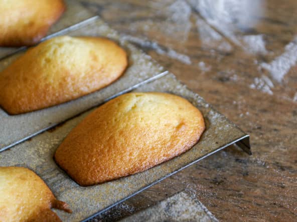 Fournée de madeleines dans un moule sur un marbre fariné