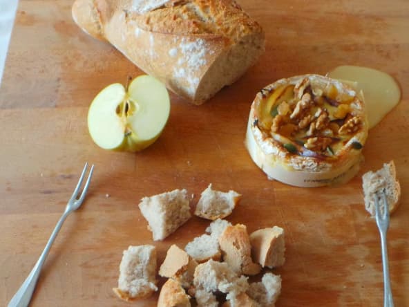 Camembert rôti au four aux pommes, miel et mélange de raisins et noix.