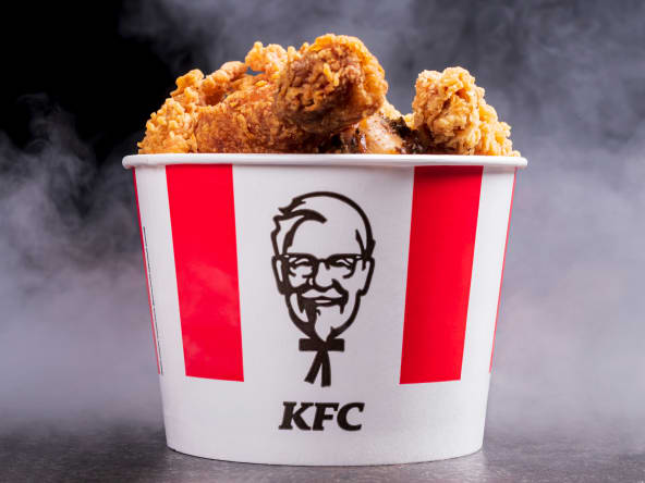 Pot de poulet frit KFC sur fond noir avec vapeur