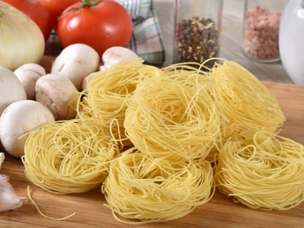 Cheveux d'ange sur fond de champignons, oignons, tomate