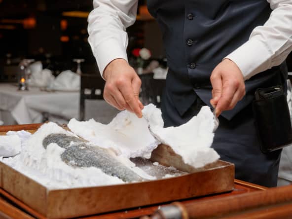 Service d'un poisson cuit en croûte de sel.