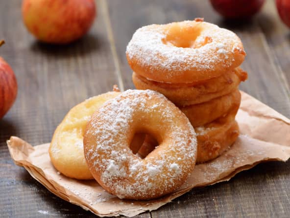 Beignets aux pommes et pommes sur table bois