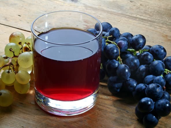 Verre de jus de raisin et grappes