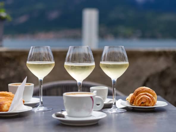 Verres de prosseco, expresso et croissants sur table