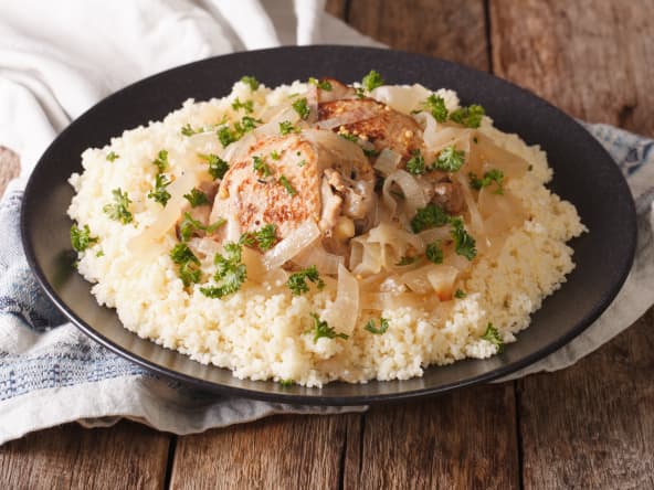 Poulet yassa et semoule sur assiette noire
