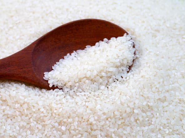 Riz japonais cru avec une cuillère en bois