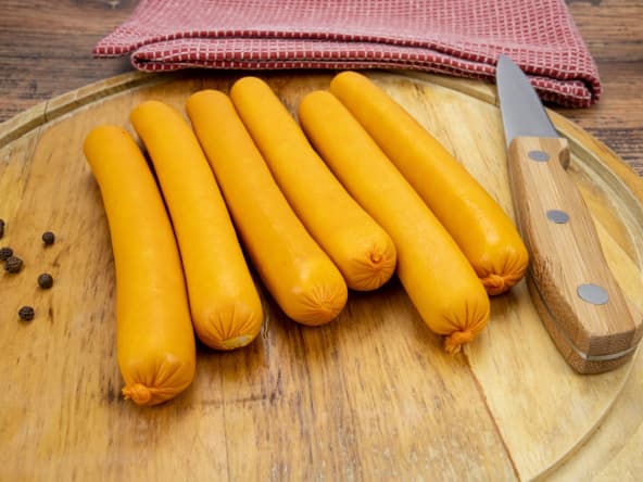 Saucisses de Strasbourg sur une planche à découper, avec un couteau de cuisine