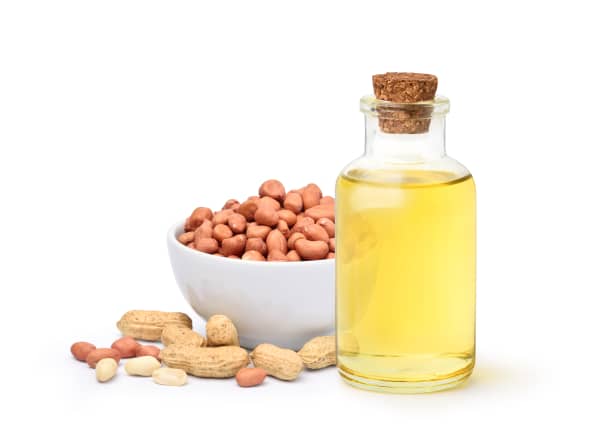 Bouteille d'huile d'arachide et bol de cacahuètes 