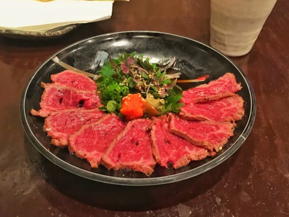 Tataki de boeuf Wagyu sur assiette noire