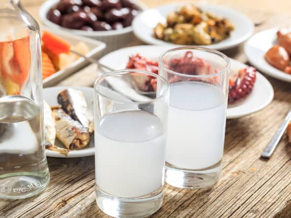 2 verres de ouzo et mezzés sur table en bois