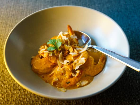 Cari de crevettes servi dans une assiette creuse