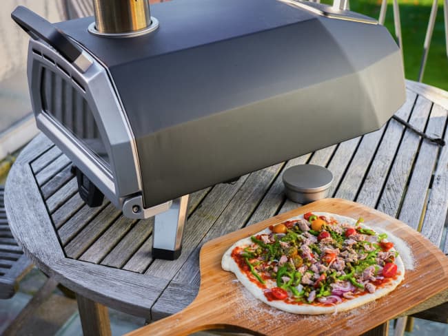 Four à pizza Ooni et pizza sur une pelle prête à être enfournée