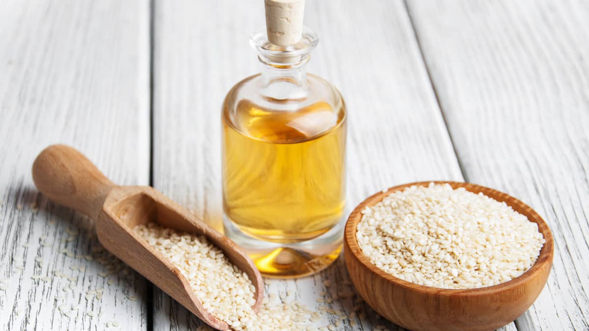 Des graines de sésame et une petite bouteille d'huile de sésame
