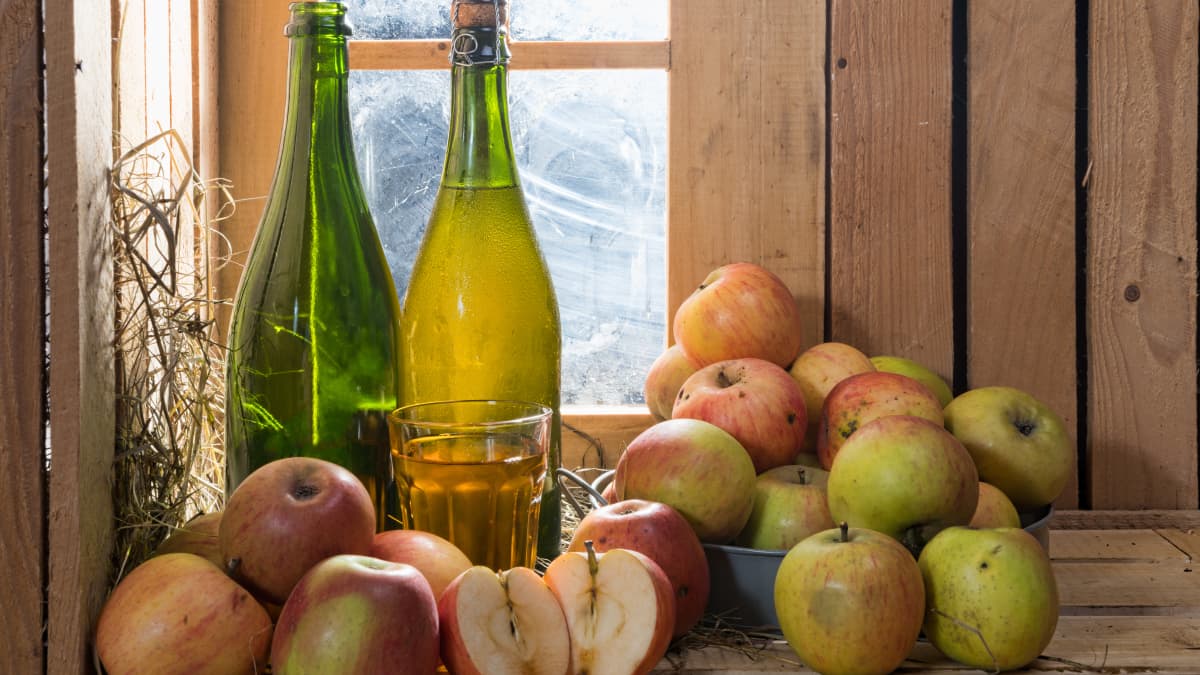 Bouteilles, verre de cidre et pommes