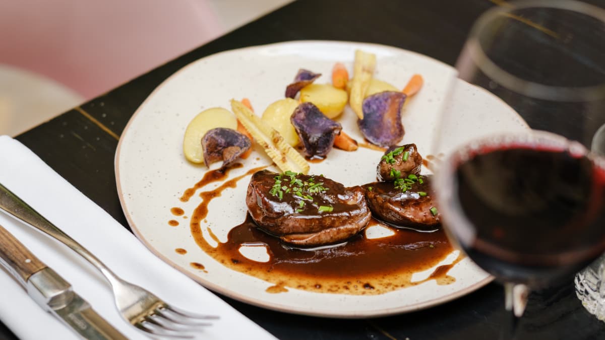 Bœuf et légumes servi avec du vin rouge