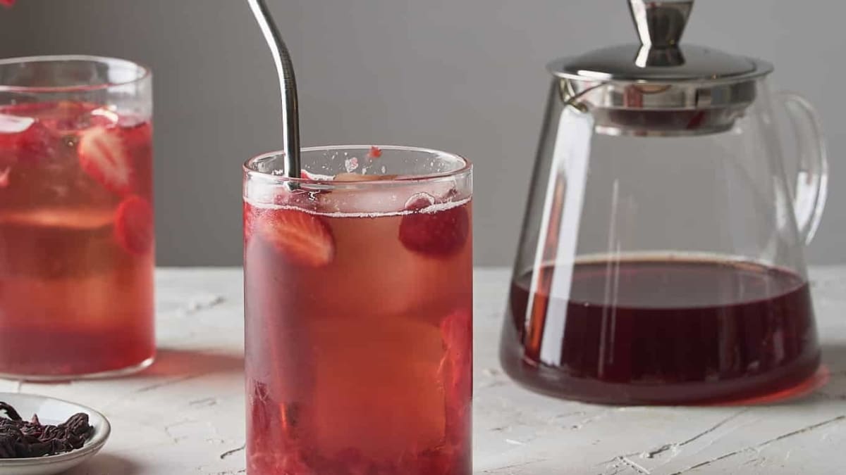 Verres et théière de thé glacé hibiscus et fraise