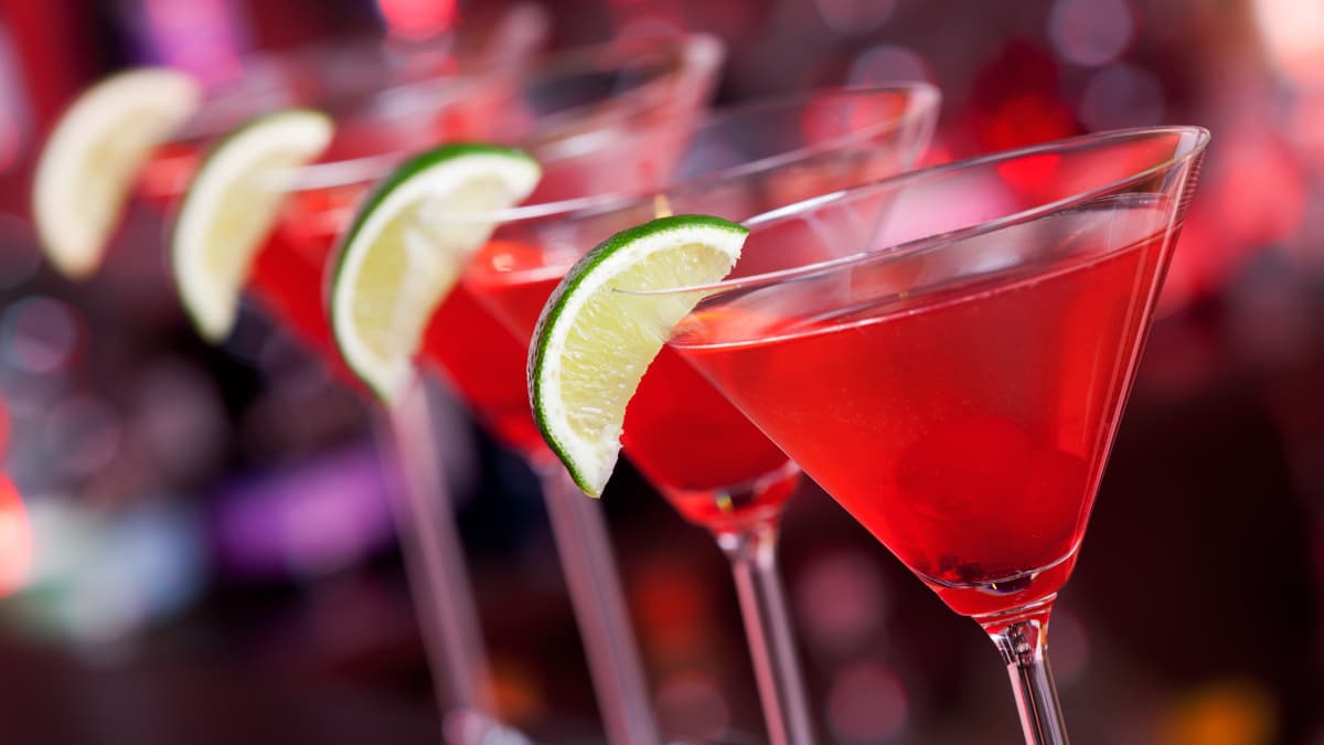 Alignement de verres de cocktails cosmopolitan sur un comptoir