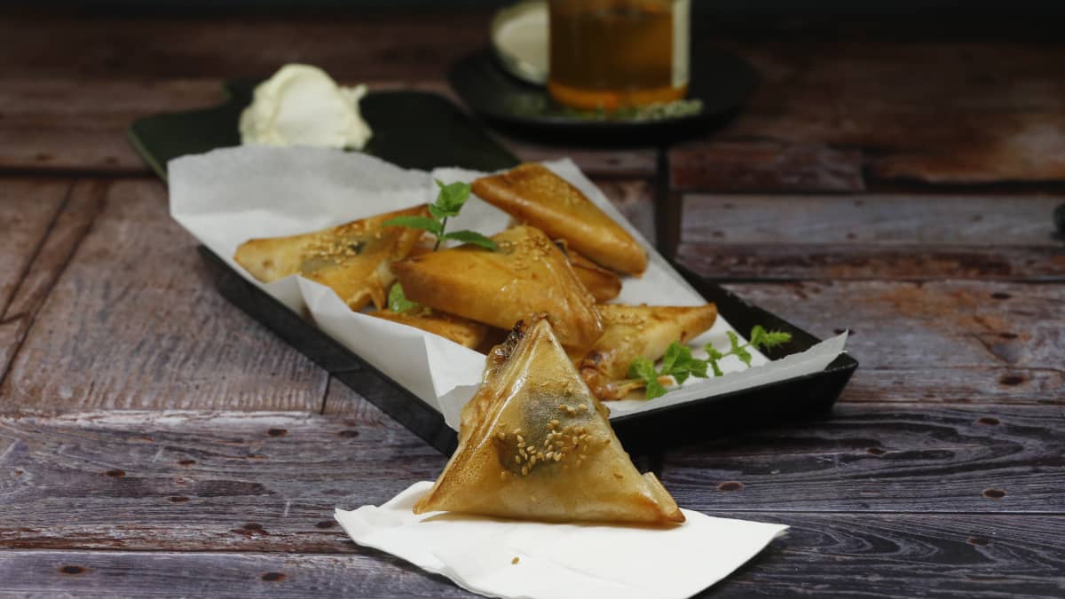 Plat de samoussas au chabichou menthe et miel, sur une table en bois