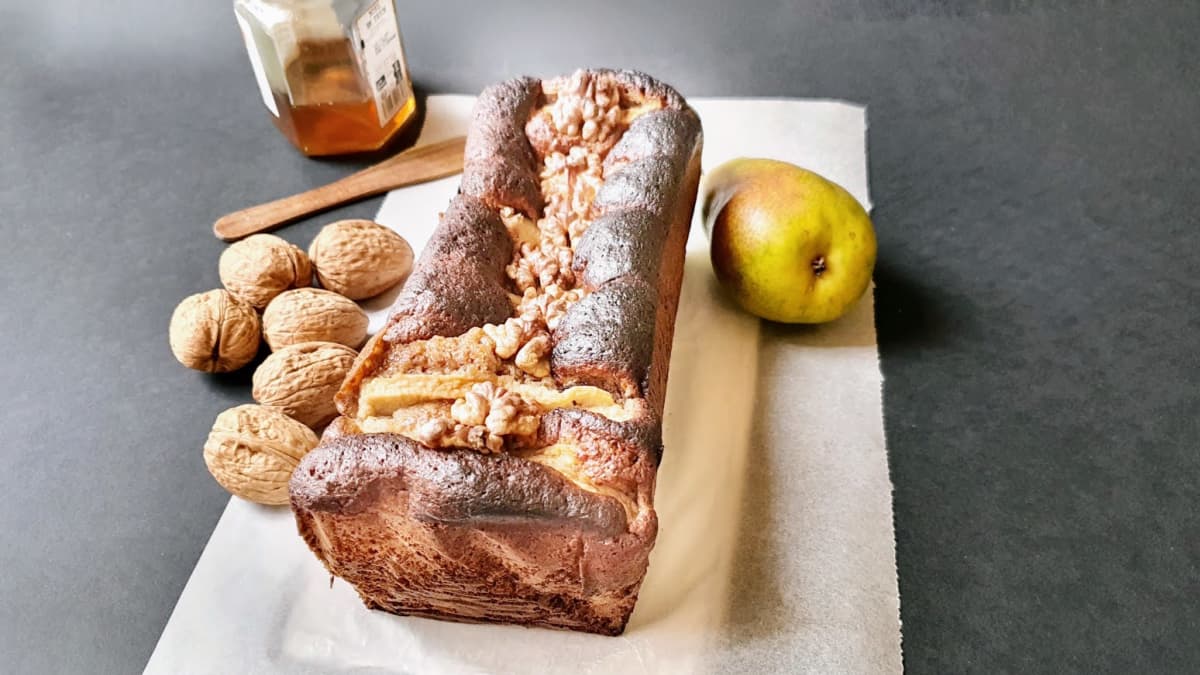 Fondant aux noix et poires, pot de miel, noix fraîches et pommes