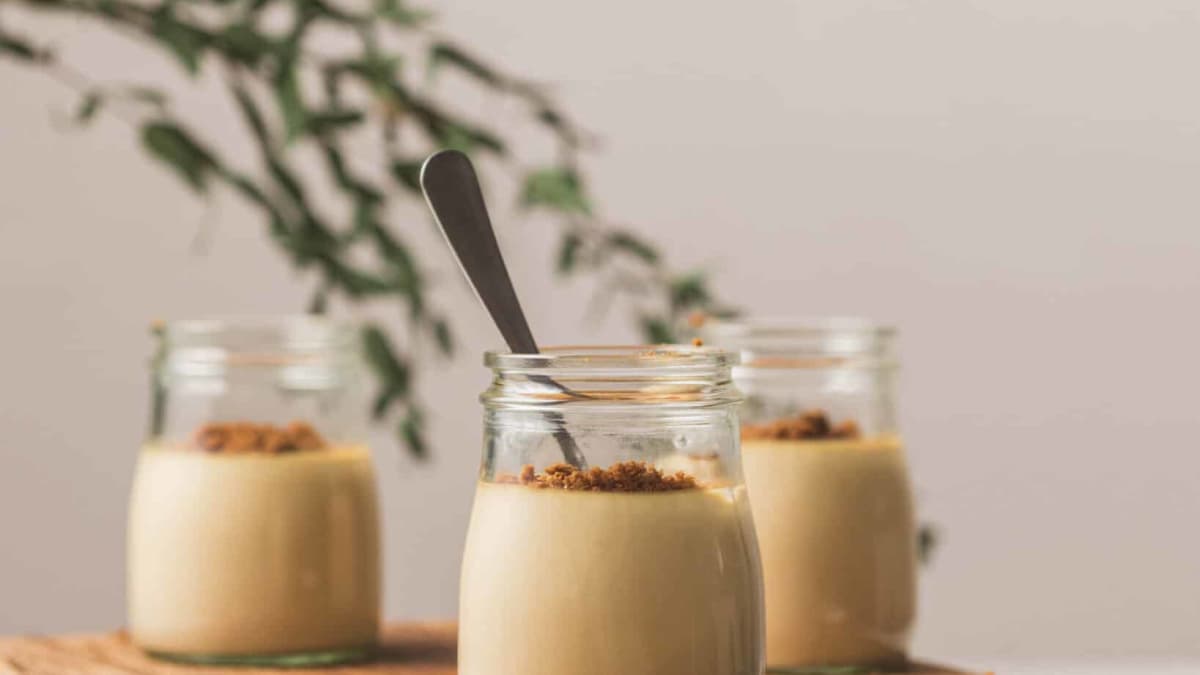 3 petits pots de panna cotta aux spéculoos posés sur une table